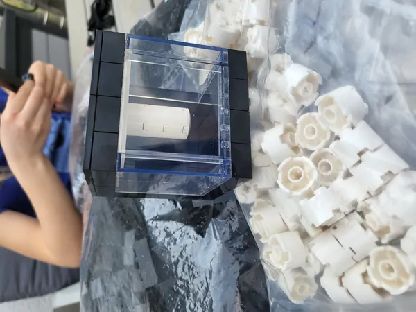 The first Quantego, a LEGO model of IBM Quantum System One, next to a bag of white LEGO bricks