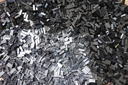 A pile of black 2x4 LEGO bricks